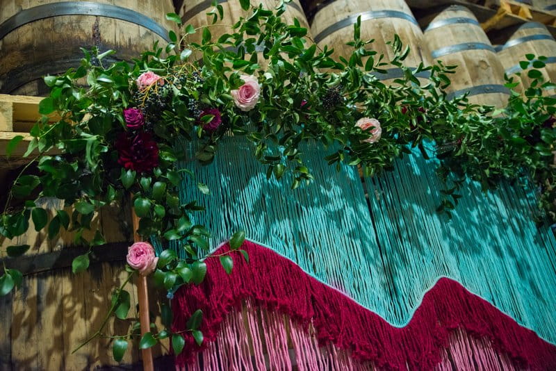 Wedding ceremony backdrop of coloured tassels and flowers