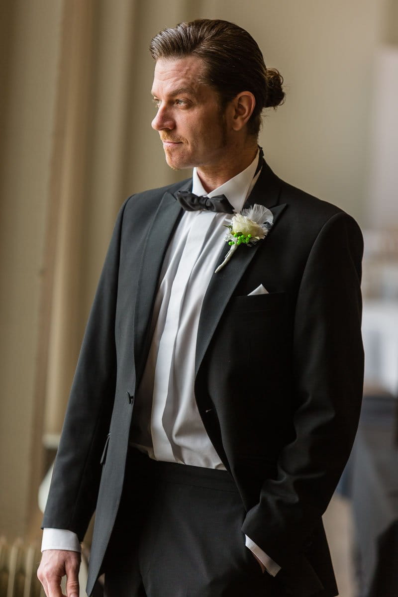 Groom in black suit and bow tie