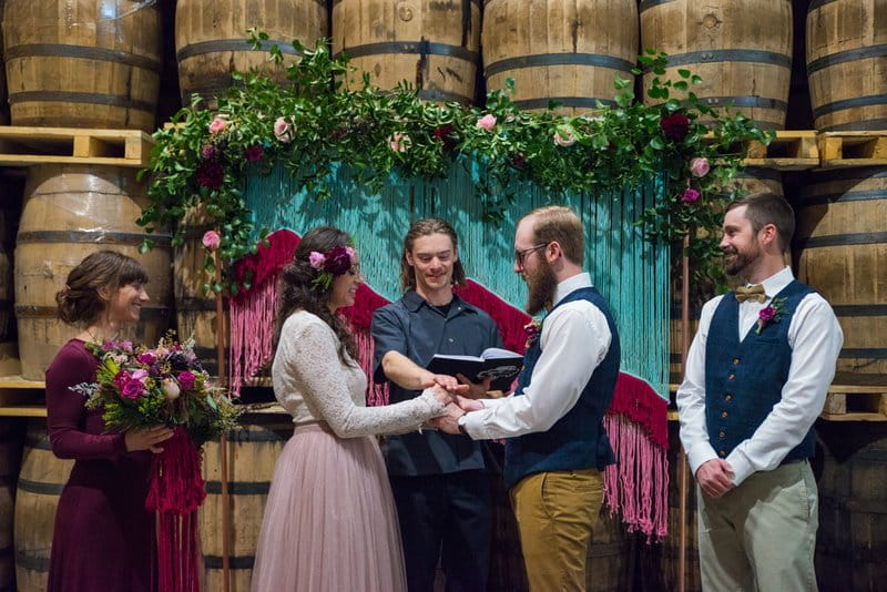 Wedding ceremony in front of barrels at Breckenridge Distillery