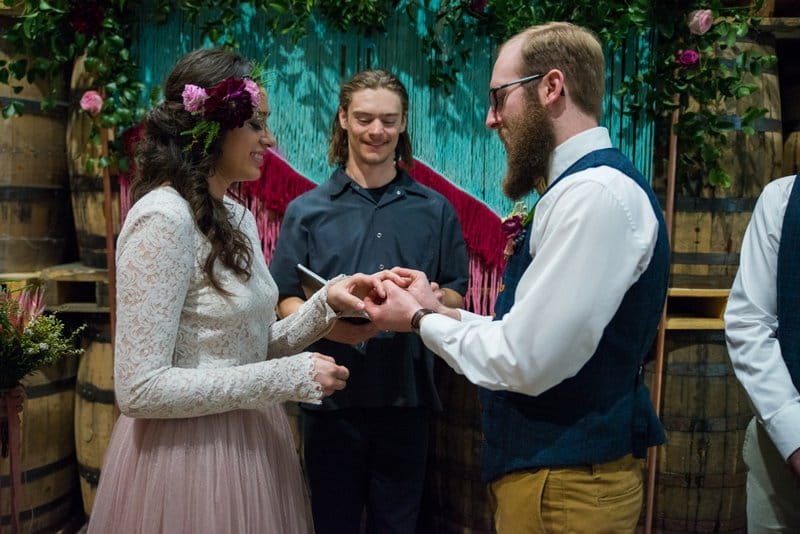 Groom placing ring on bride's finger