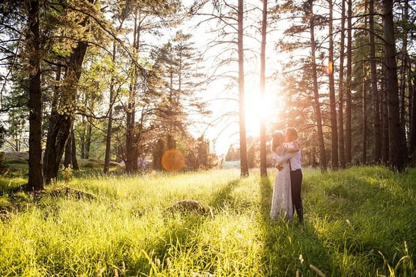 Bride and groom in woodland with sun shining through the trees - Picture by Jessica Grace Photography