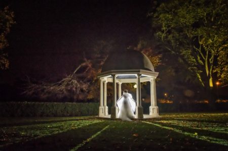 Bride being lit up in gazebo in grounds of wedding venue at night - Picture by Image-i-Nation Photography