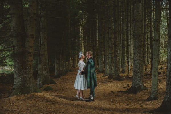 Bride facing Scottish groom surrounded by trees - Picture by The Drawing Room