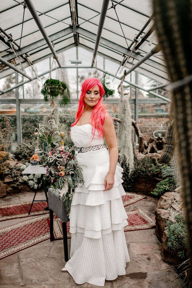 Bride with pink hair wearing wedding dress with ruffle layered skirt