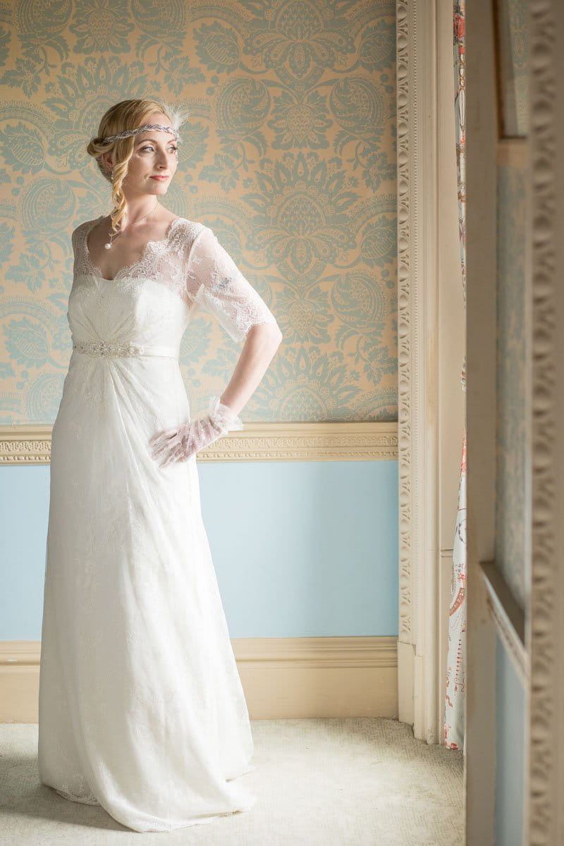 Vintage bride looking out of window of Heythrop Park