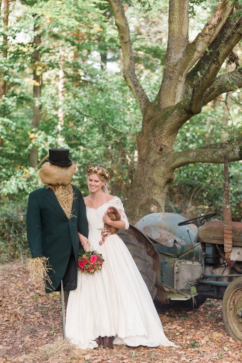 Bride standing in woodland next to groom scarecrow