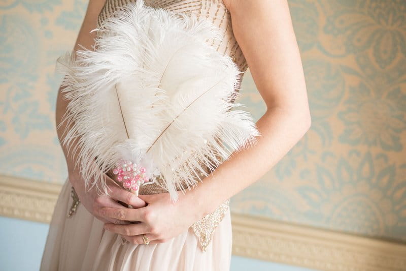 Bridesmaid holding feathers instead of bouquet