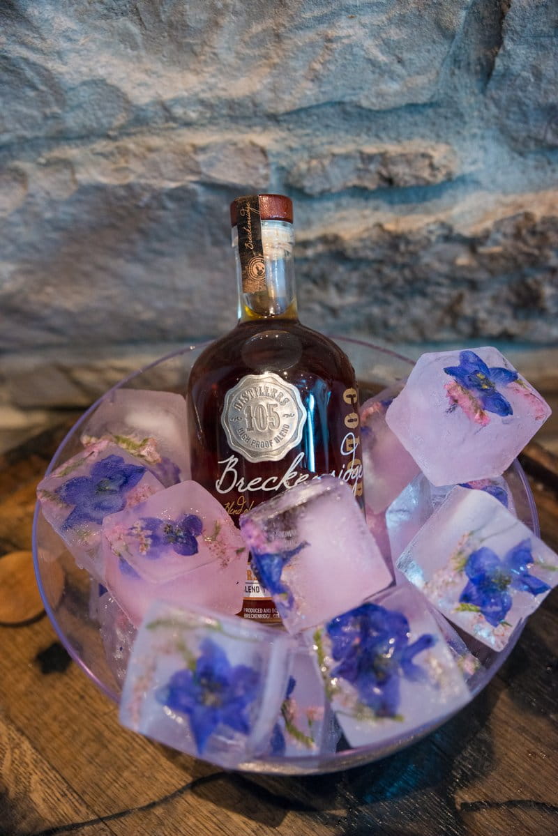 Whisky with ice cubes with flowers in