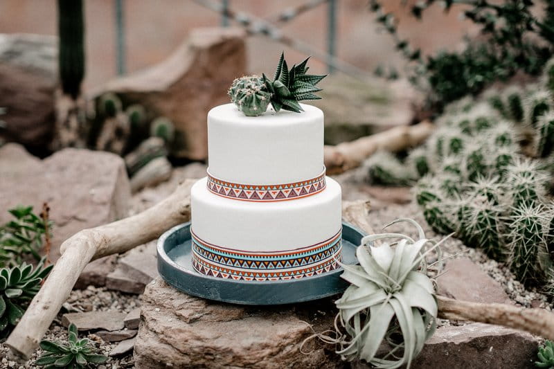 White wedding cake with cactus topper