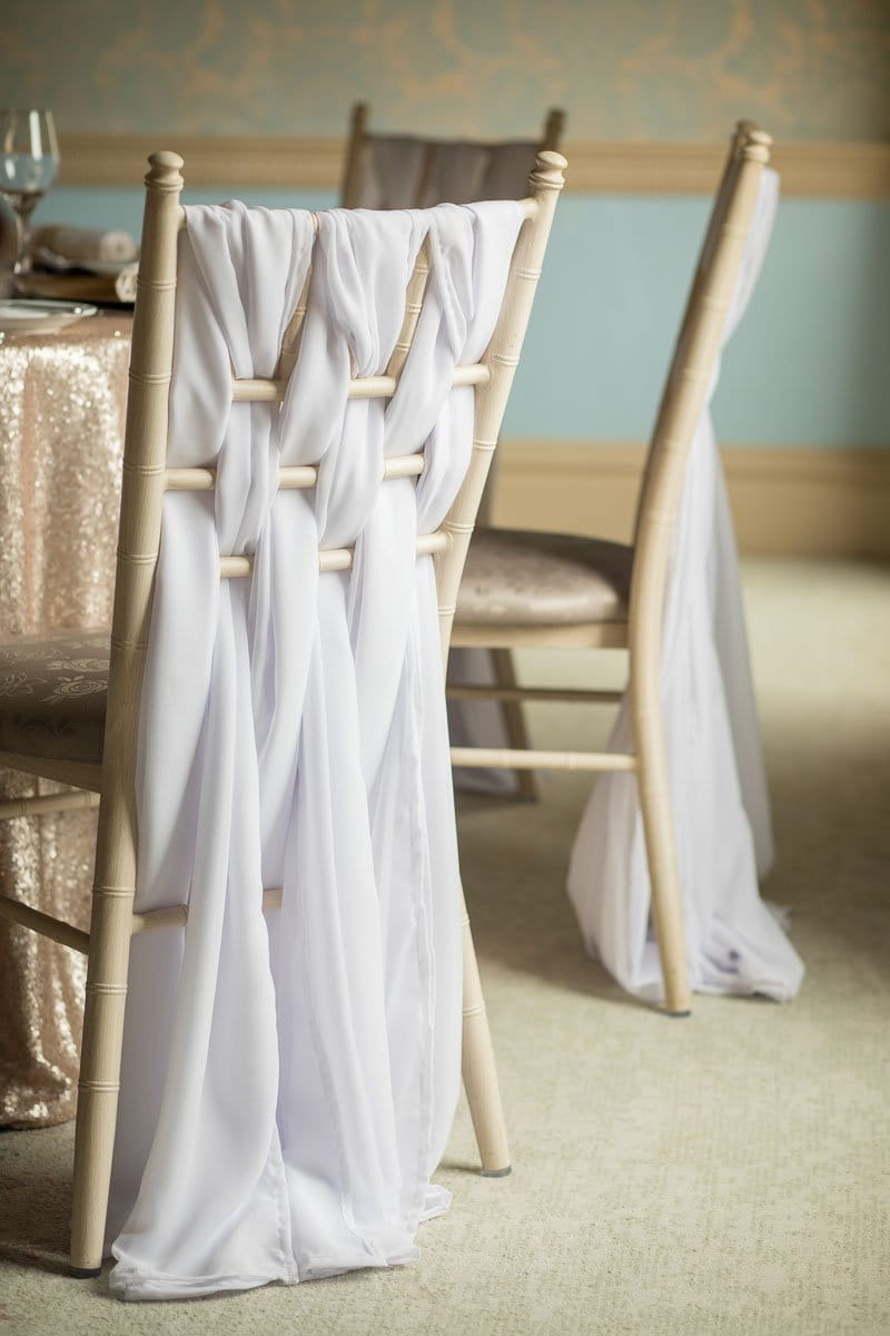 Wedding chairs with chiffon weaved through