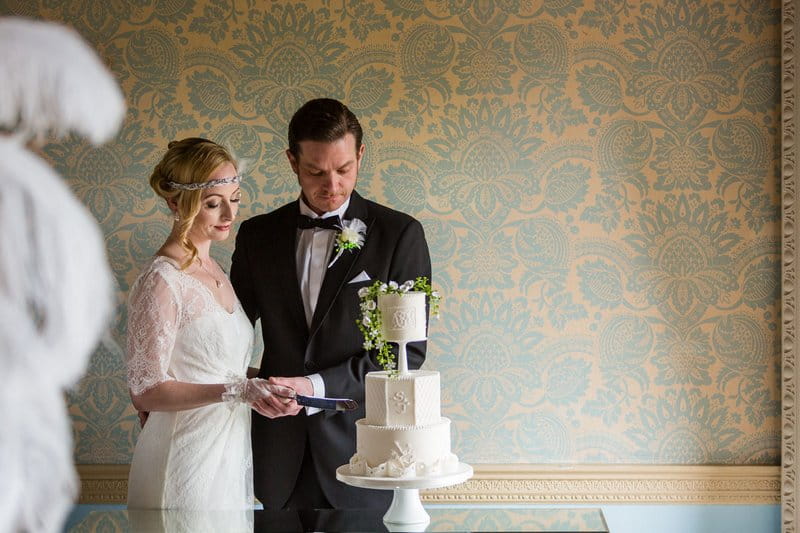 Vintage bride and groom cutting wedding cake