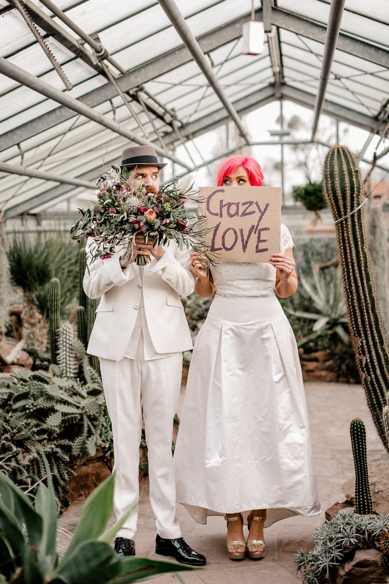 Groom holding bouquet and bride holding crazy love sign