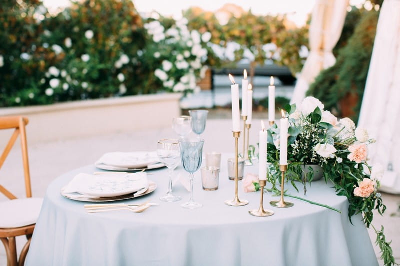 Small wedding table with dusty blue tablecloth and elegant styling