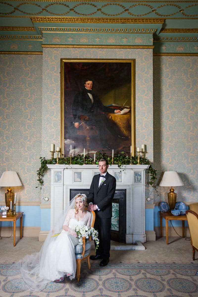 Bride and groom in front of fireplace at Heythrop Park