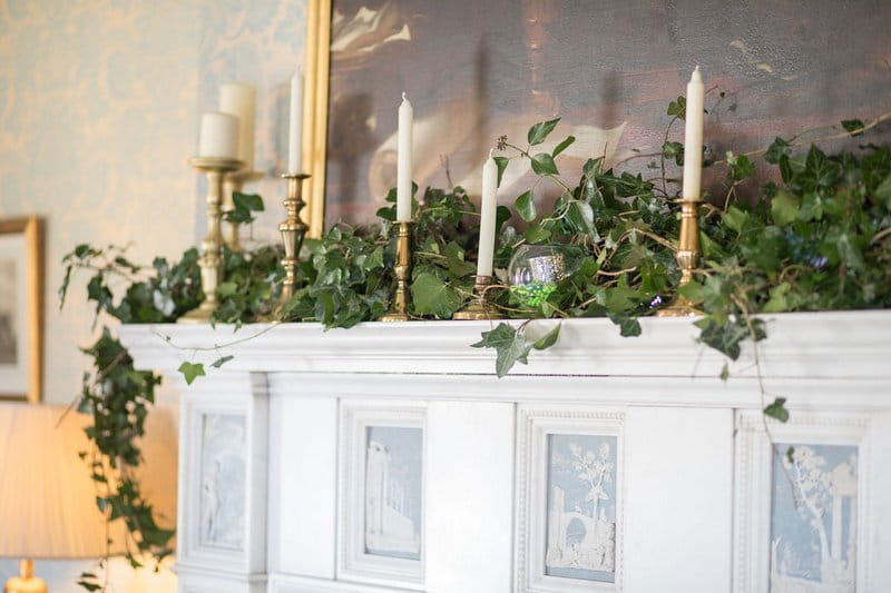 Foliage and candles on fireplace at Heythrop Park