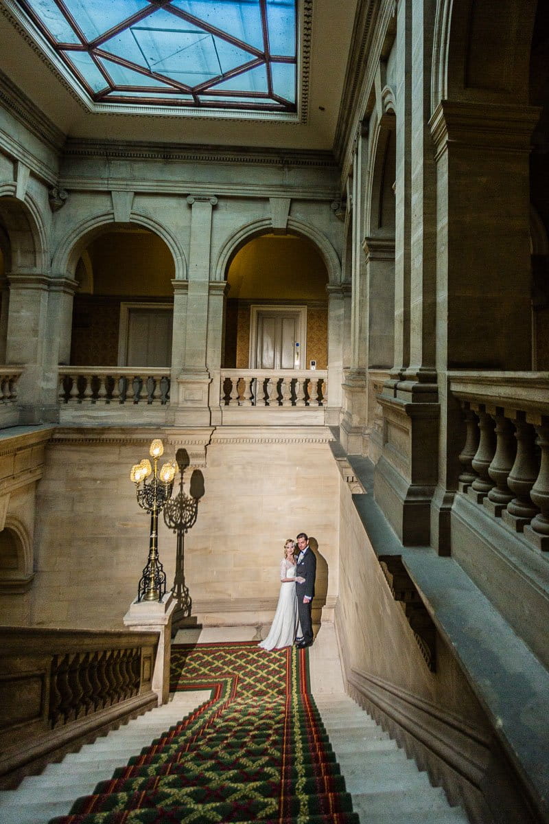 Bride and groom at bottom of steps in Heythrop Park