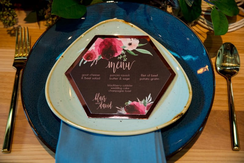 Purple wedding menu on blue charger plate