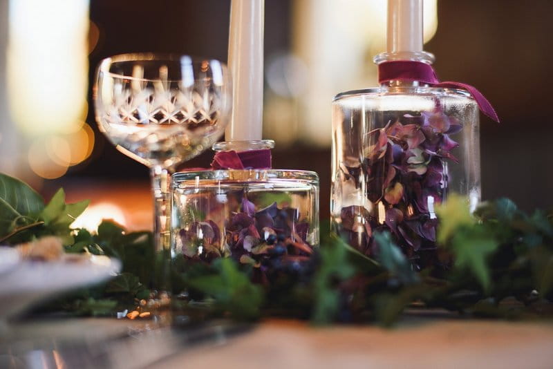 Purple hydrangea petals in bottle candle holder