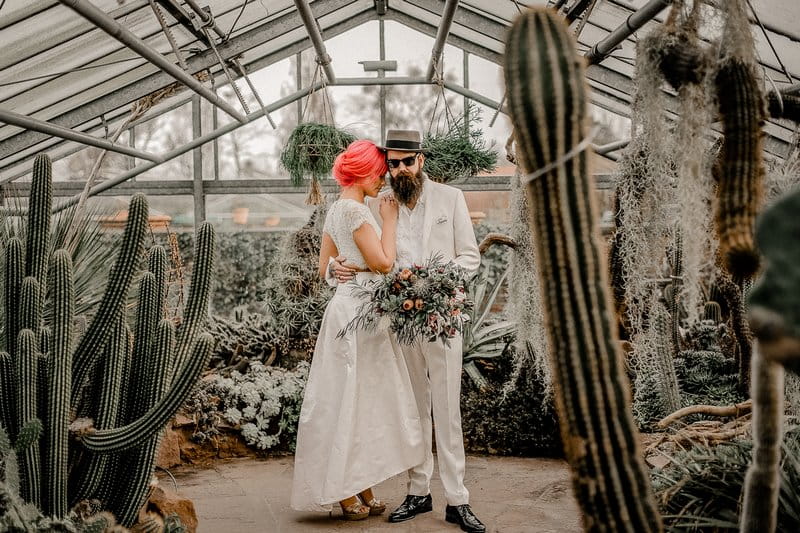 Bride and groom in greenhouse full of cactuses