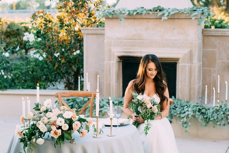 Bride sitting at small wedding table