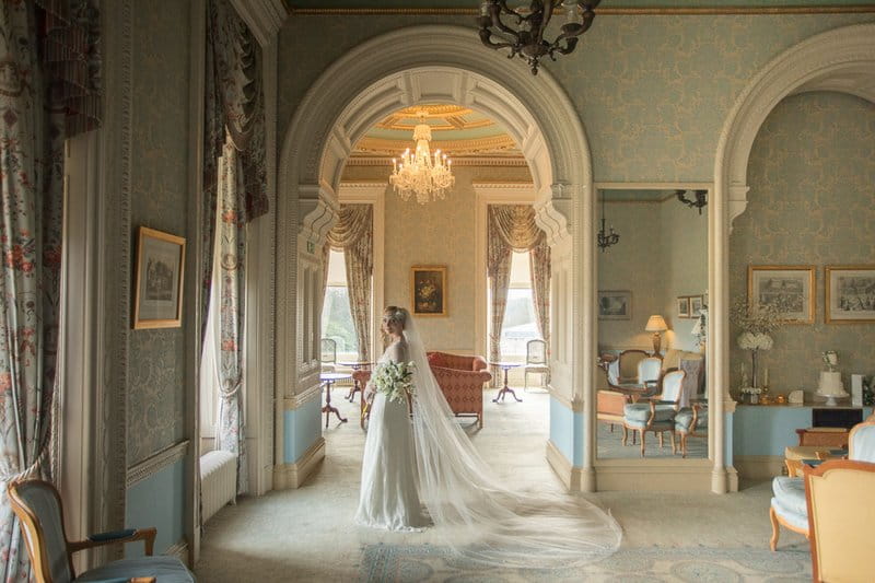 Bride looking out of window of Heythrop Park