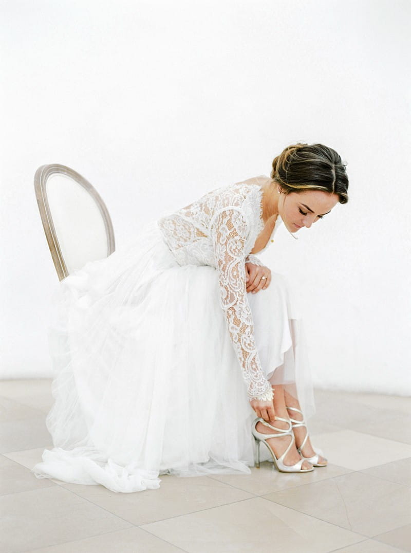 Bride putting on Jimmy Choo wedding shoes