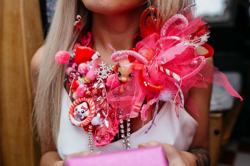 Large red necklace made from toys and ribbons