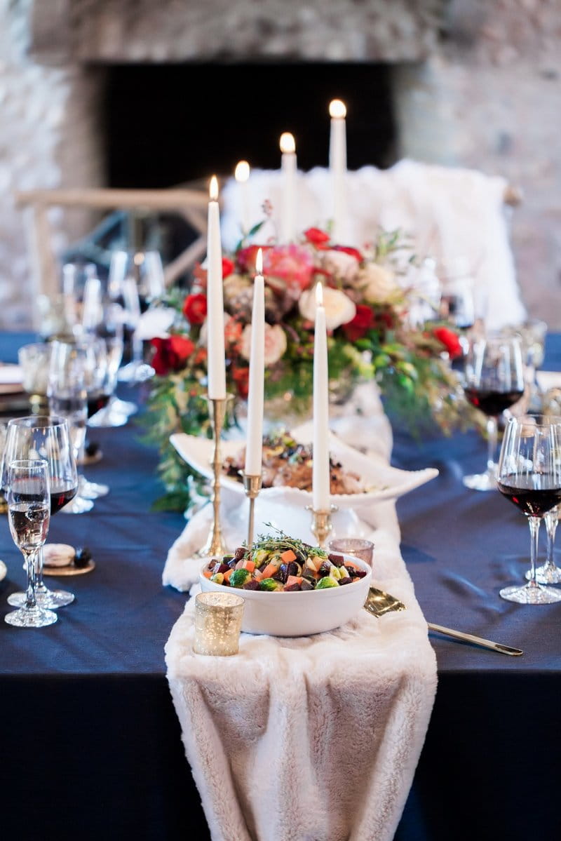 Candles and food on top of white fur wedding table runner