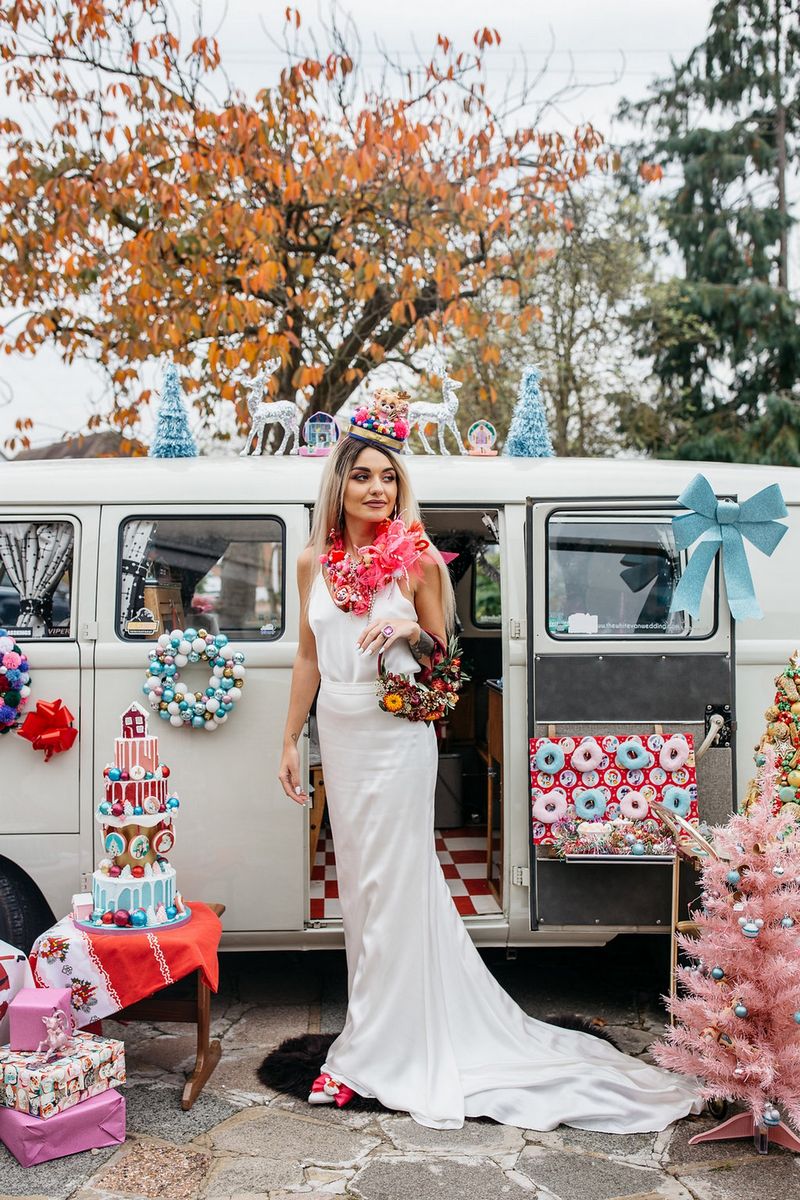 Bride outside VW camper van surrounded by kitsch Christmas props