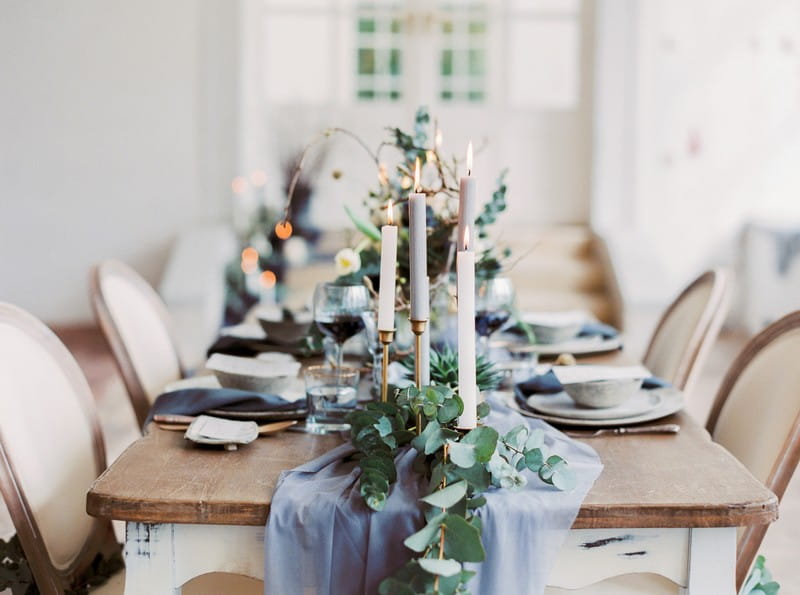 Candles and foliage on grey table runner