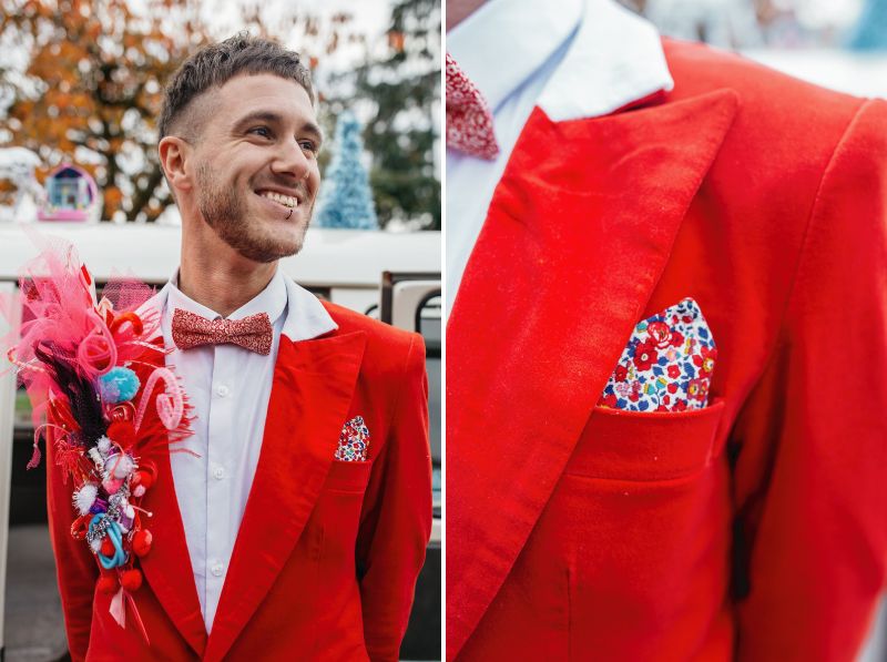 Groom wearing red suit with colourful pocket square and lapel piece