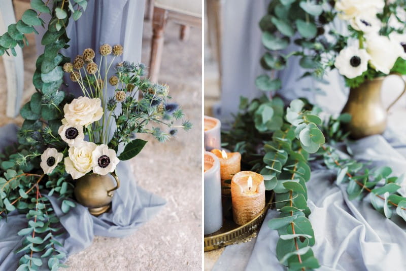 Pot of winter flowers, green foliage and candles on end of grey table runner