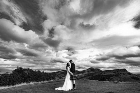 Bride and groom facing each other with dramatic clouds overhead - Picture by Ashley-Liv Jamieson Photography