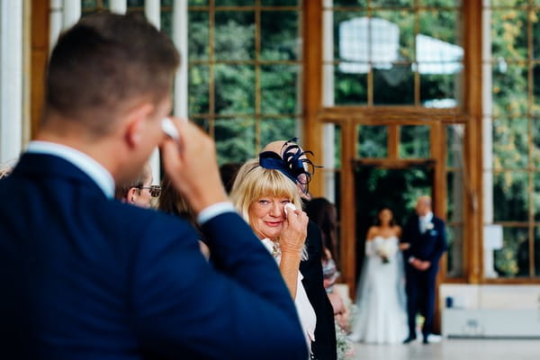 Mother and groom wiping away tears as bride walks down the aisle - Picture by Marianne Chua Photography