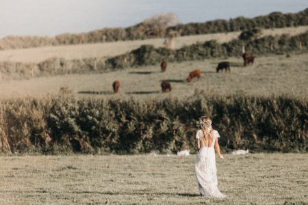 Boho bride walking across field - Picture by Ben Wigglesworth Photography