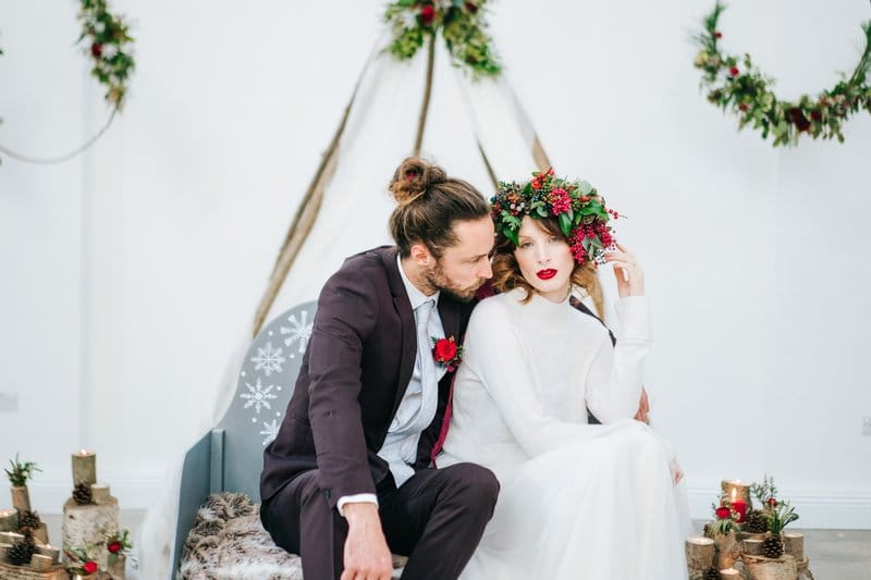 Winter bride and groom sitting on sleigh