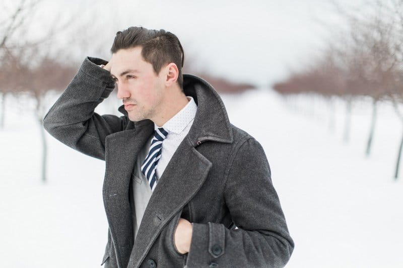 Groom with long coat in snow