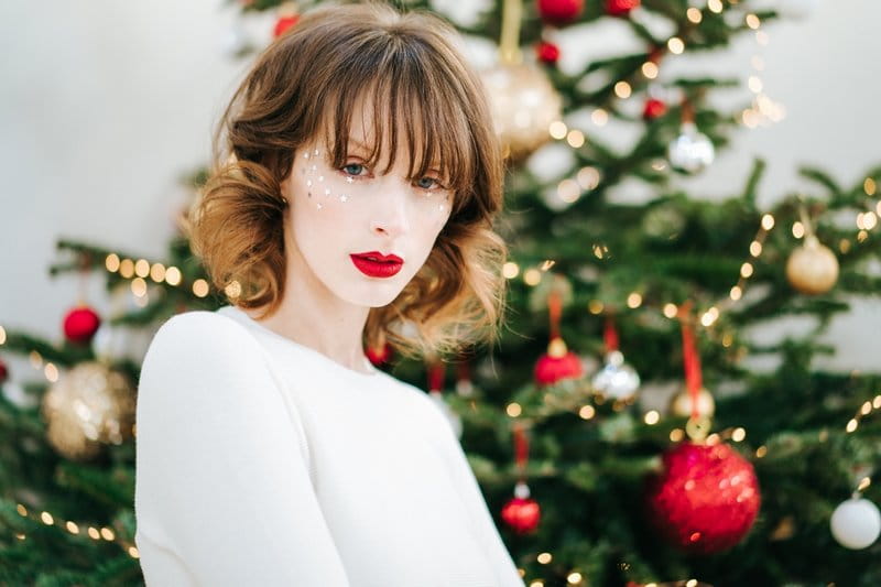 Bride with fringe hairstyle standing in front of Christmas tree