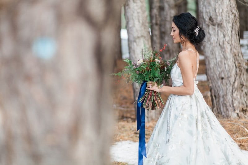 Bride carrying bouquet with blue ribbon