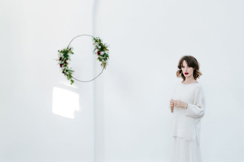 Bride standing by foliage hoop