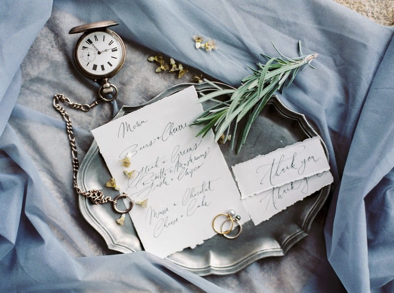 Hand-written wedding menu and name cards on grey cloth