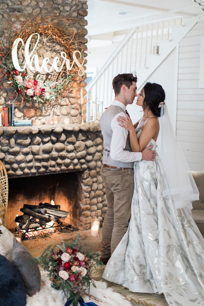 Bride and groom by cosy fireplace