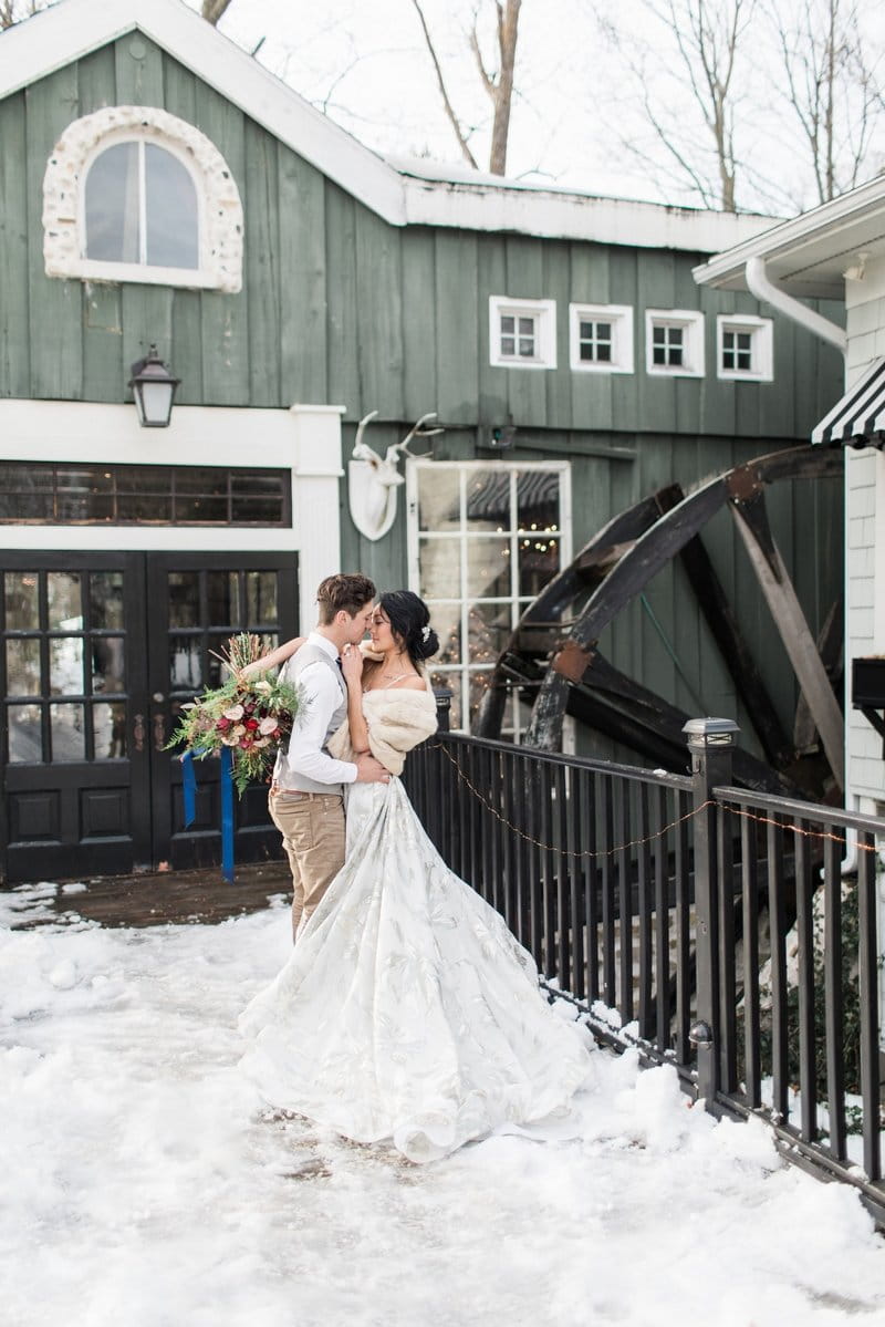 Bride and groom outside Willowbrook Mill in the snow