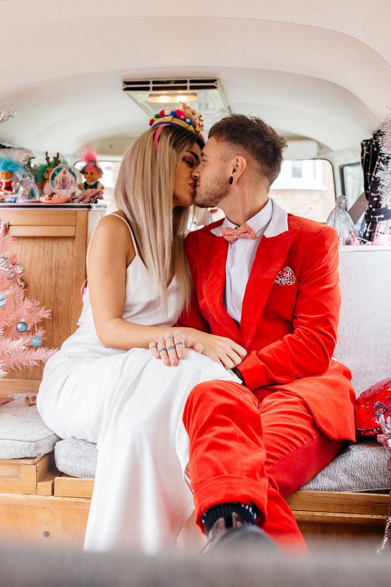 Bride kissing groom in red suit