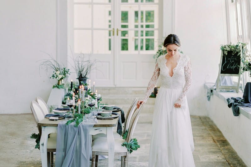 Bride standing next to table with grey wedding styling