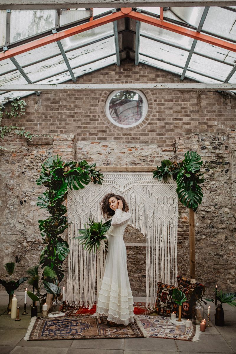Bride standing in front of macramé wedding backdrop