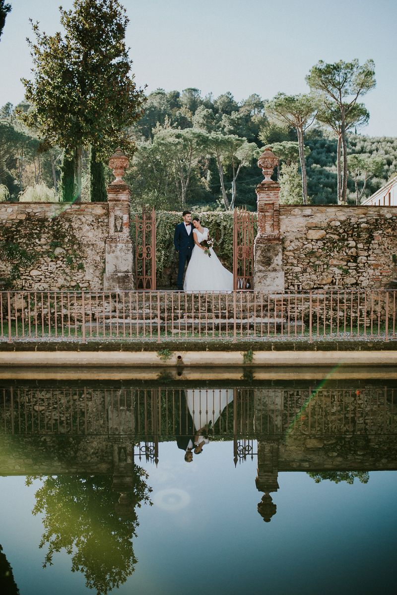 Bride and groom by water in Tuscany