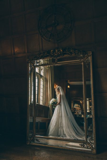Reflection in mirror of bride standing by window - Picture by Emma-Jane Photography