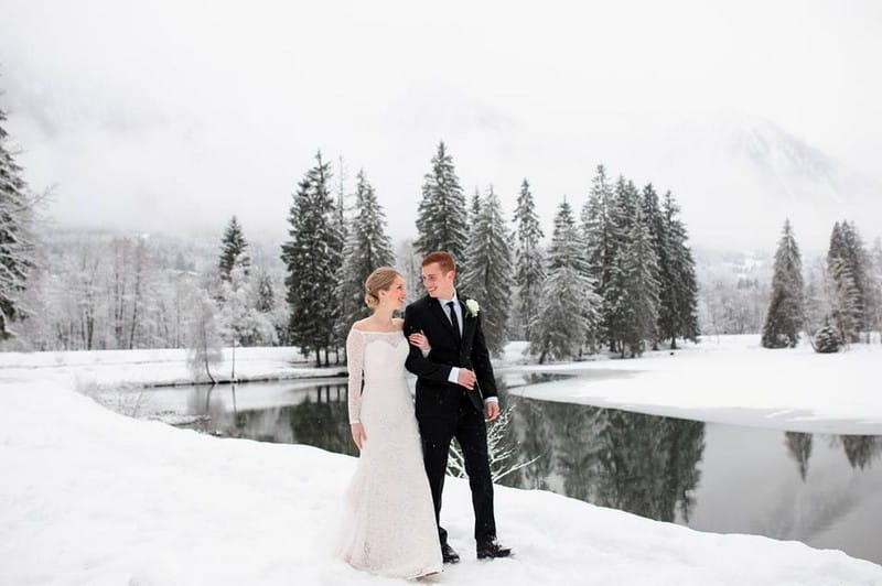 Bride and groom walking by lake in the snow - Picture by Airsnap