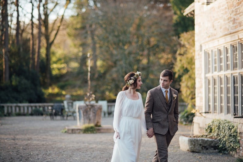 Bride and groom walking in grounds of Coombe Trenchard